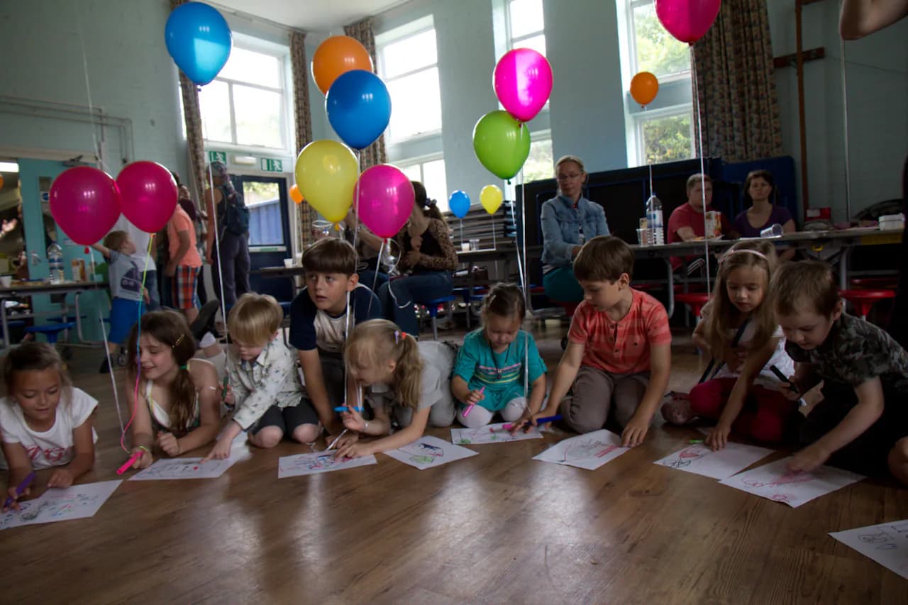 Children writing and drawing on the floor during a school activity.