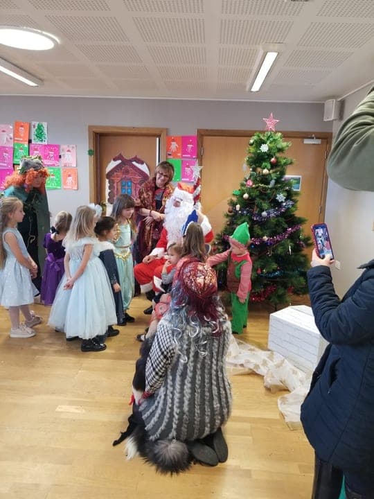 Children meeting festive characters during a school celebration.