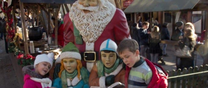 Children gathered around a seasonal winter market display.
