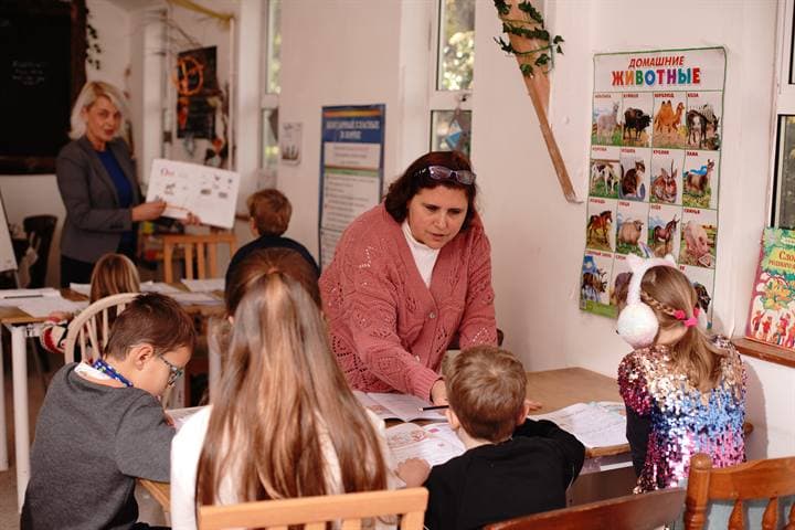 A teacher working with children during a classroom lesson.