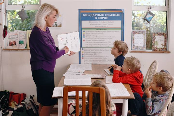 A teacher standing beside a classroom learning display.