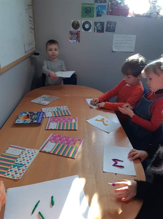 Children taking part in a seated classroom activity.