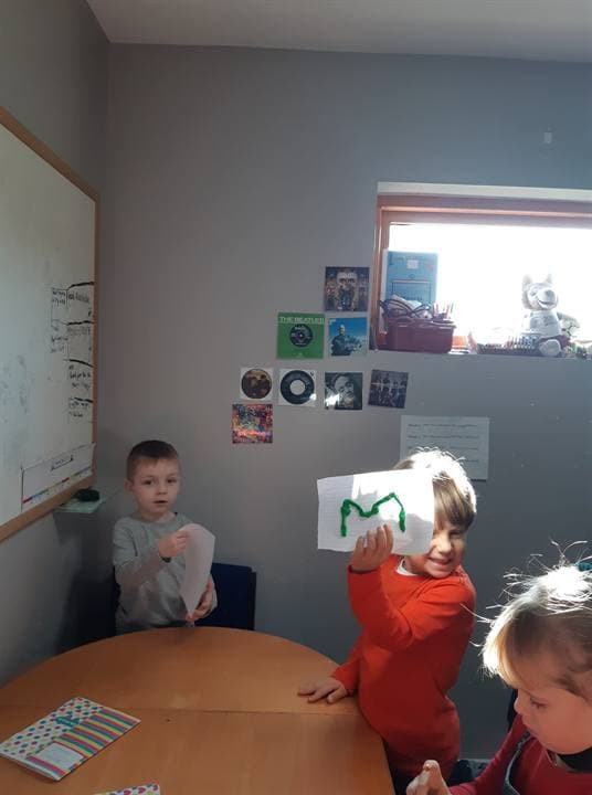Children working around a classroom table during a lesson.