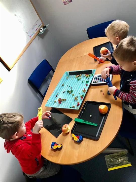 Children working at a small classroom table.