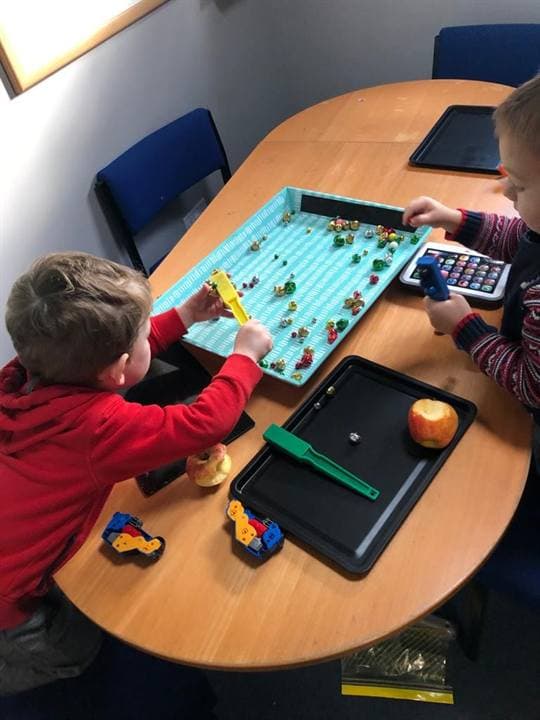 Children using classroom learning materials at a table.