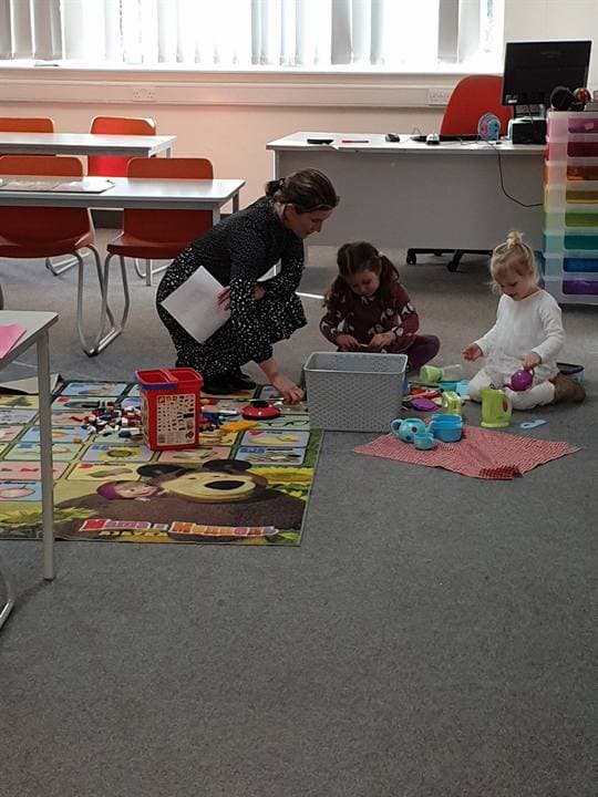 Children working on a floor activity in a classroom.