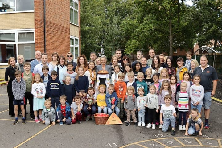 A school group gathered outside for a community photograph.
