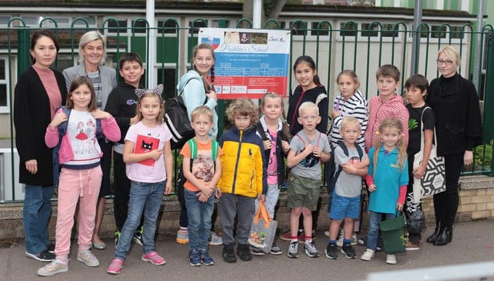 A school group gathered outside a venue entrance.