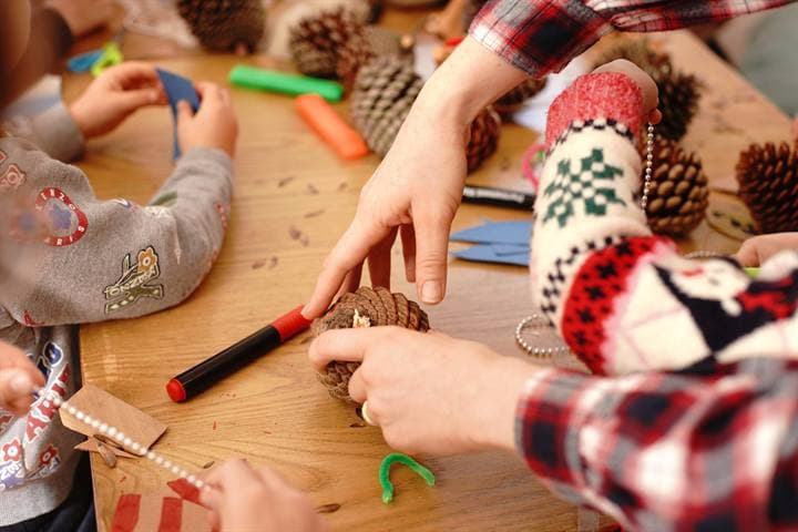 Hands using craft materials during a classroom creative activity.