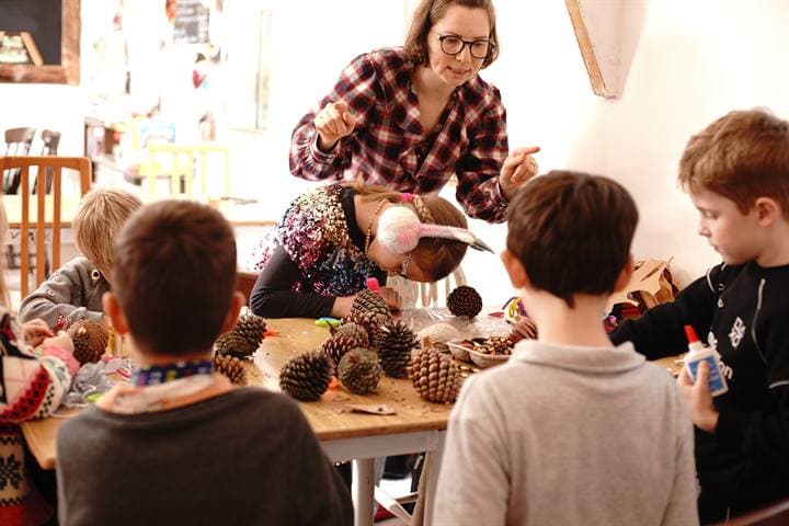 A teacher leading a hands-on craft activity with children.