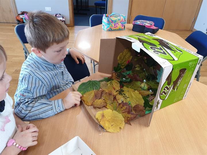 A child working with a model project on a classroom table.