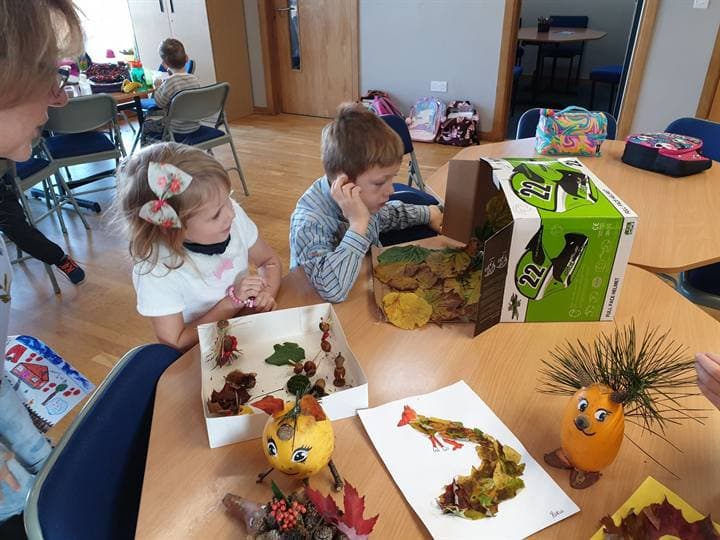 Children working together around a classroom craft table.