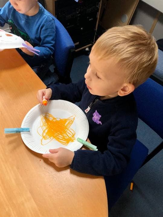 A child working on a paper craft during a classroom activity.