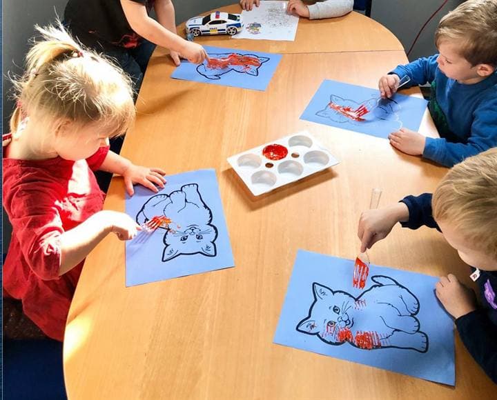 Children colouring drawings during a classroom activity.