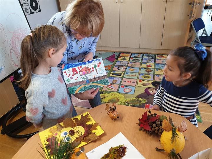 Children and a teacher gathered around craft materials.