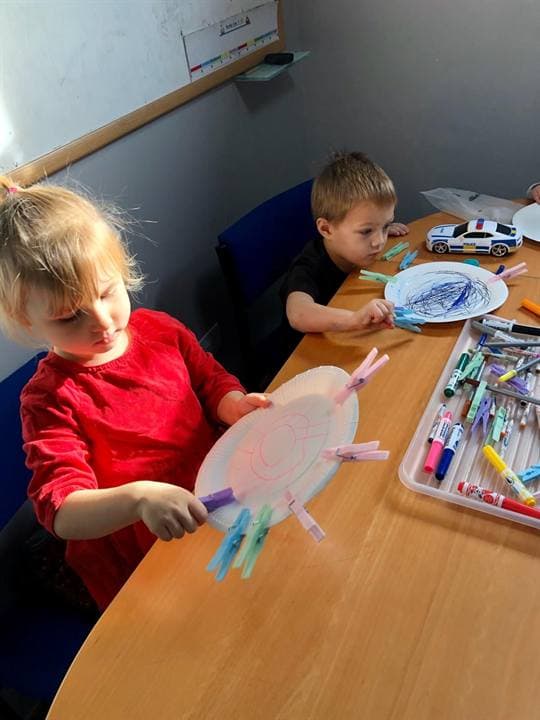 A child using classroom craft materials at a table.