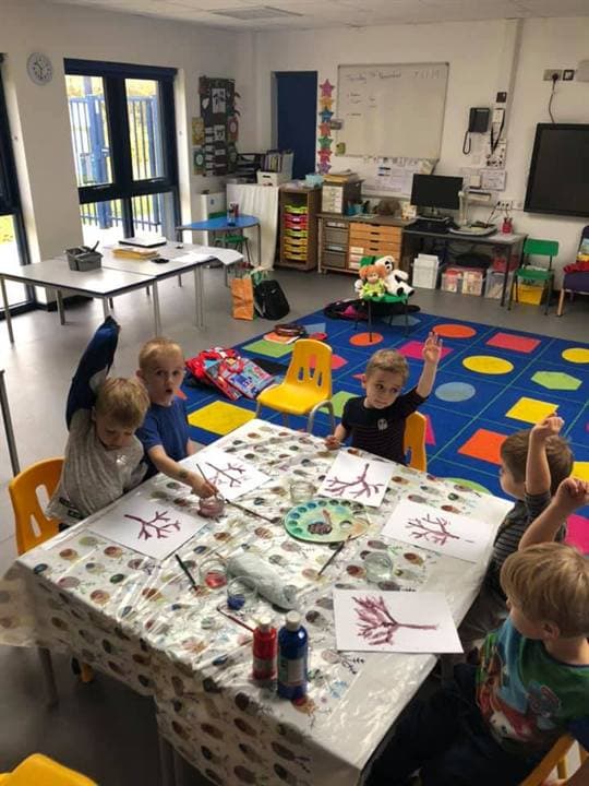 Children gathered around a creative classroom table activity.