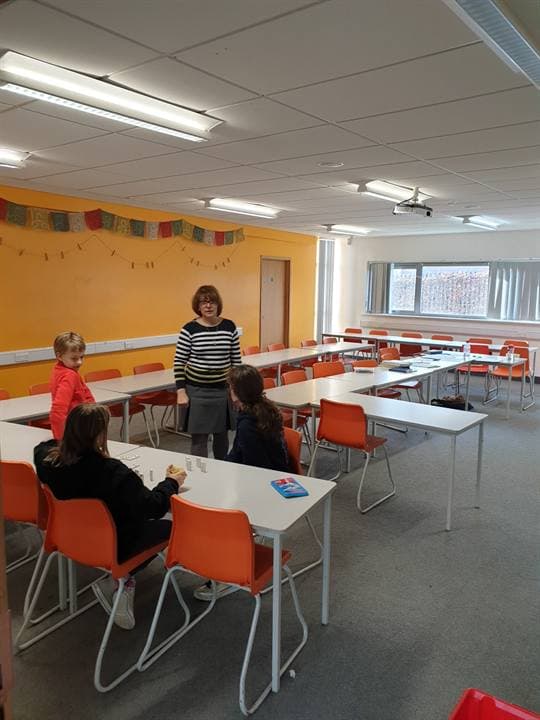 A classroom prepared with tables and learning materials.