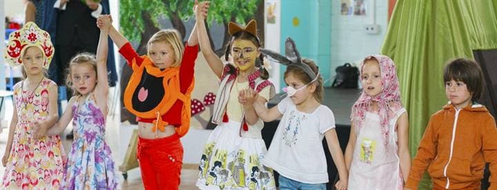 Children performing a Kolobok stage scene.