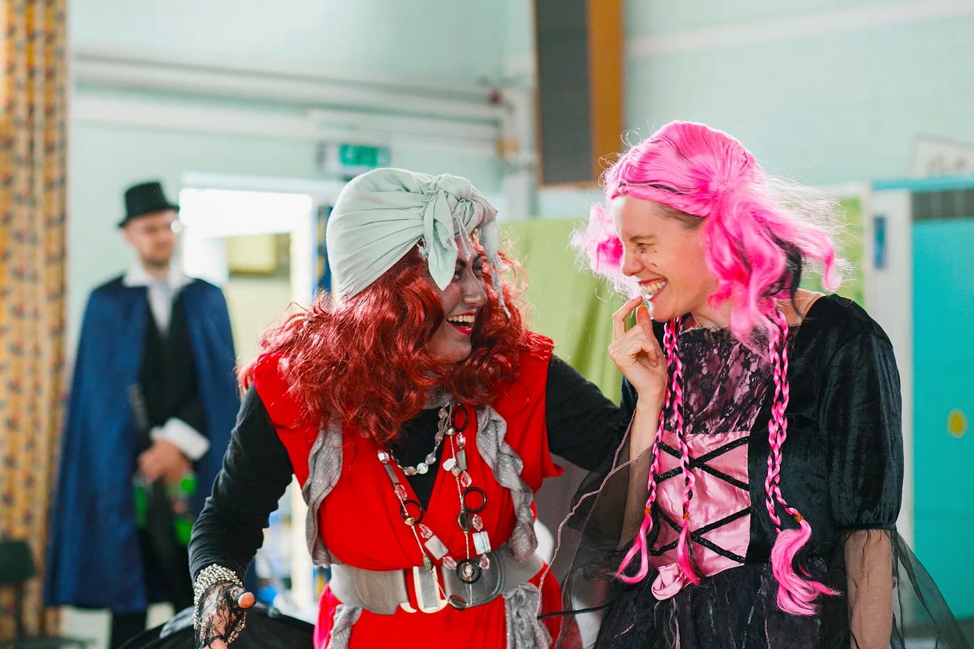 Costumed adult performers acting in a school theatre scene.