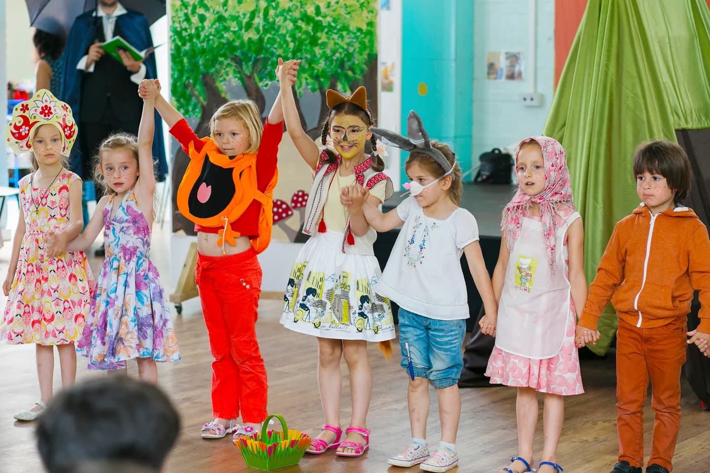 Children holding hands during a Kolobok performance curtain call.