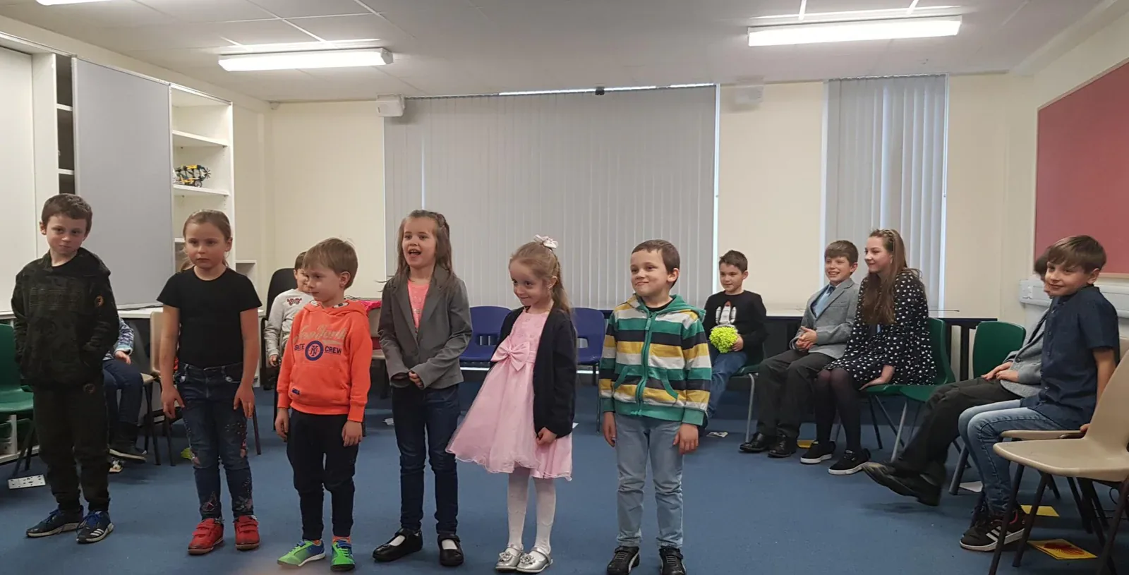 Children standing in a line during a school performance activity.