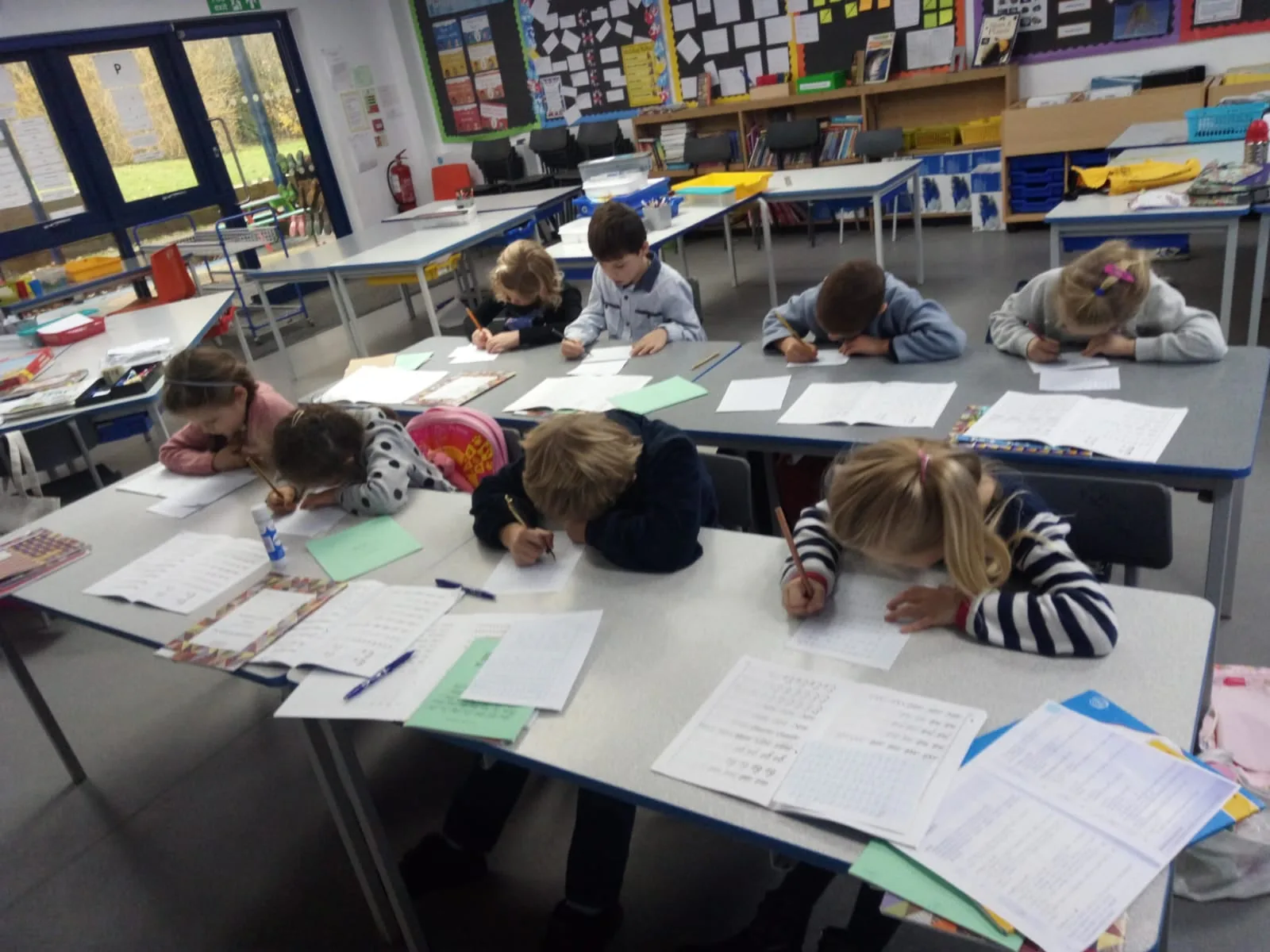 Children writing at tables in a High Wycombe classroom.